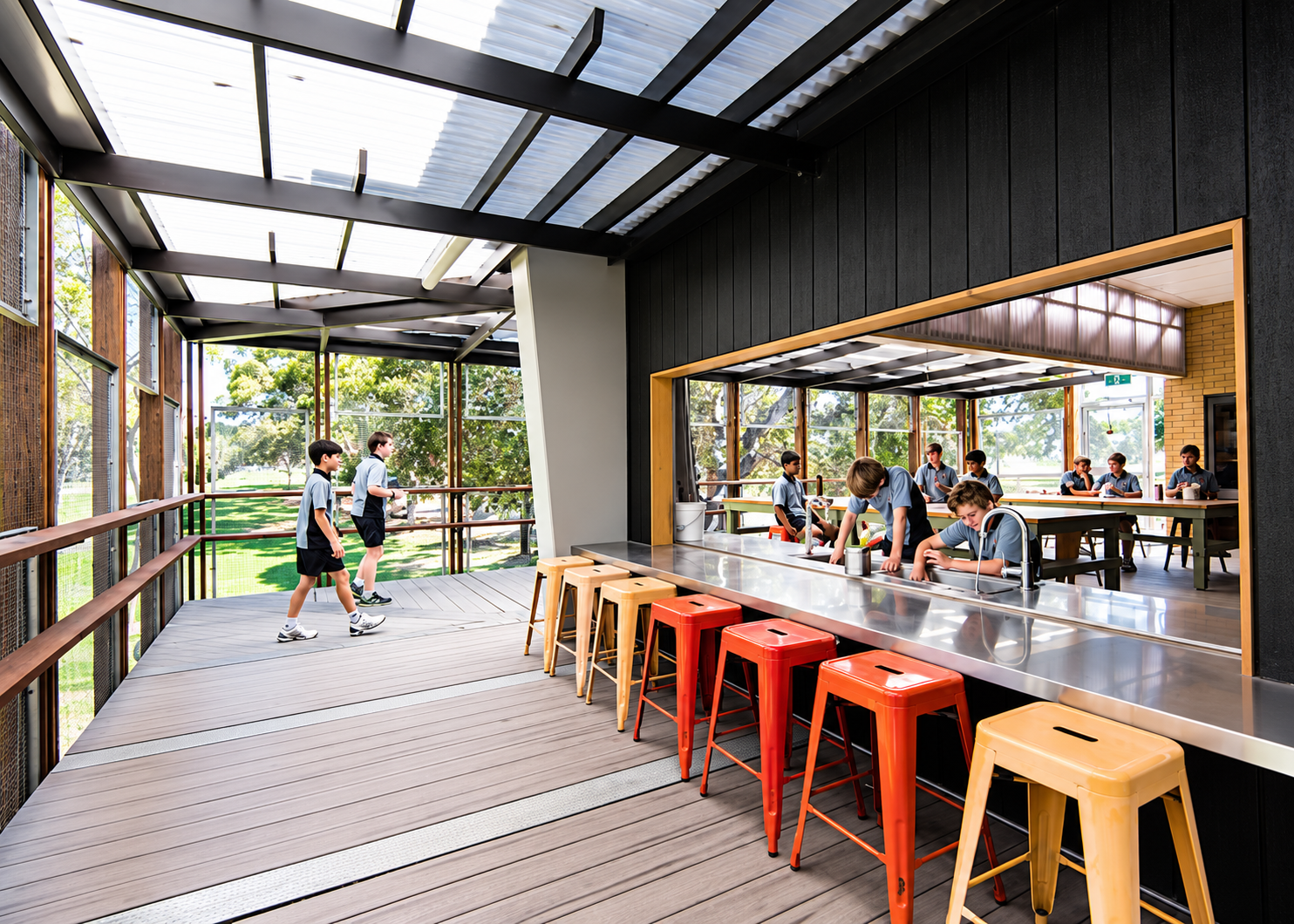 Covered outdoor learning deck with timber ceiling and long servery bench at a school